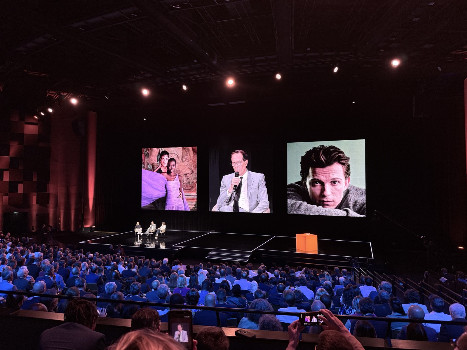 The CEO of L'Oréal on stage at the Orange Leaders Meeting in Paris, in conversation with the CEO of Orange, beauty campaign imagery projected on the screens behind them