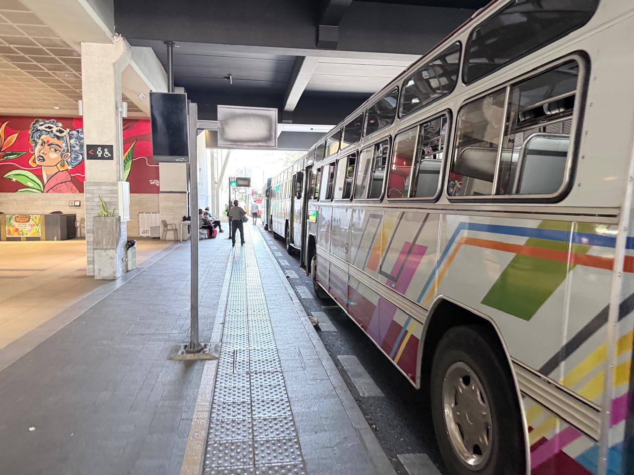 Buses lined up in their bays at the Victoria Urban Terminal in Port Louis on a quiet weekday morning, a few passengers waiting on the platform